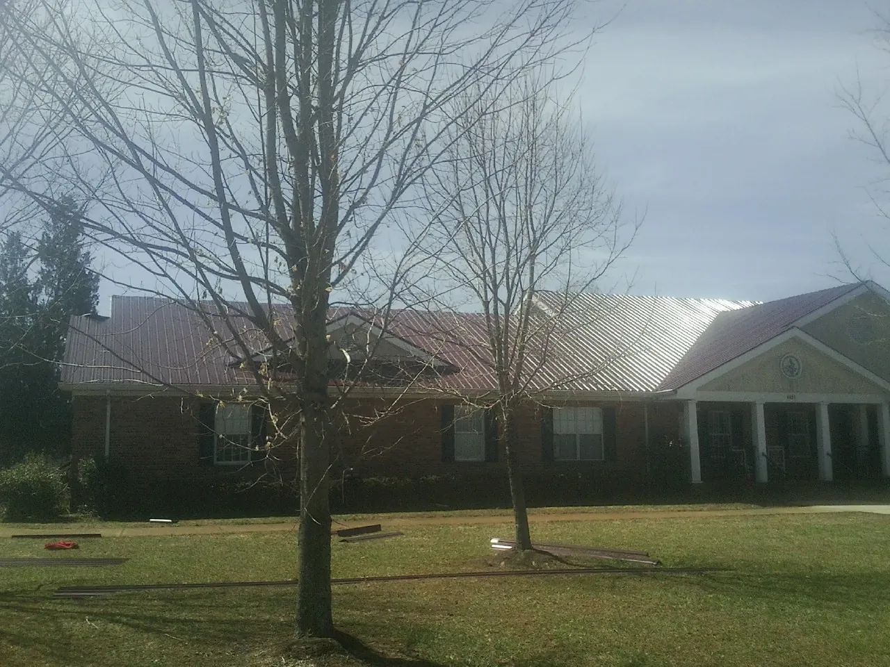 Red metal roof on a brick building seen from the front lawn in Coalfield