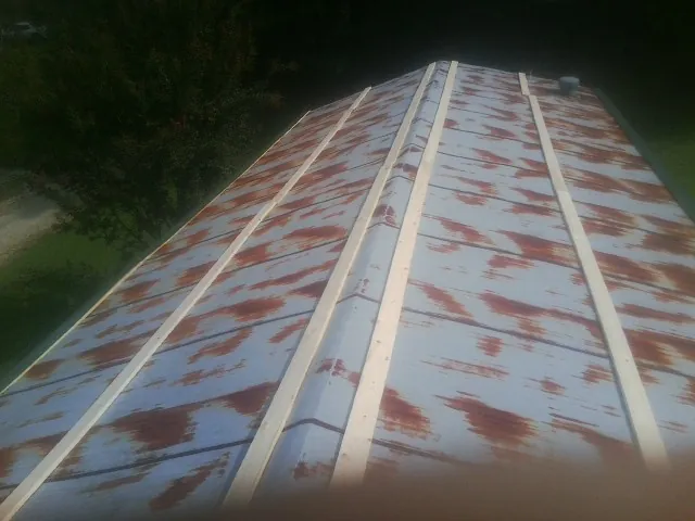 Rusted metal roof panels with new wood purlins before replacement — Storm Damage Roof Repair in Coalfield by Roofing Brothers
