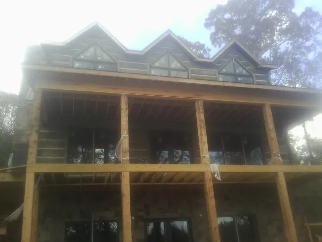 Dormers and porch framing on a large log home under construction — Roof Coating work by our crew in Coalfield
