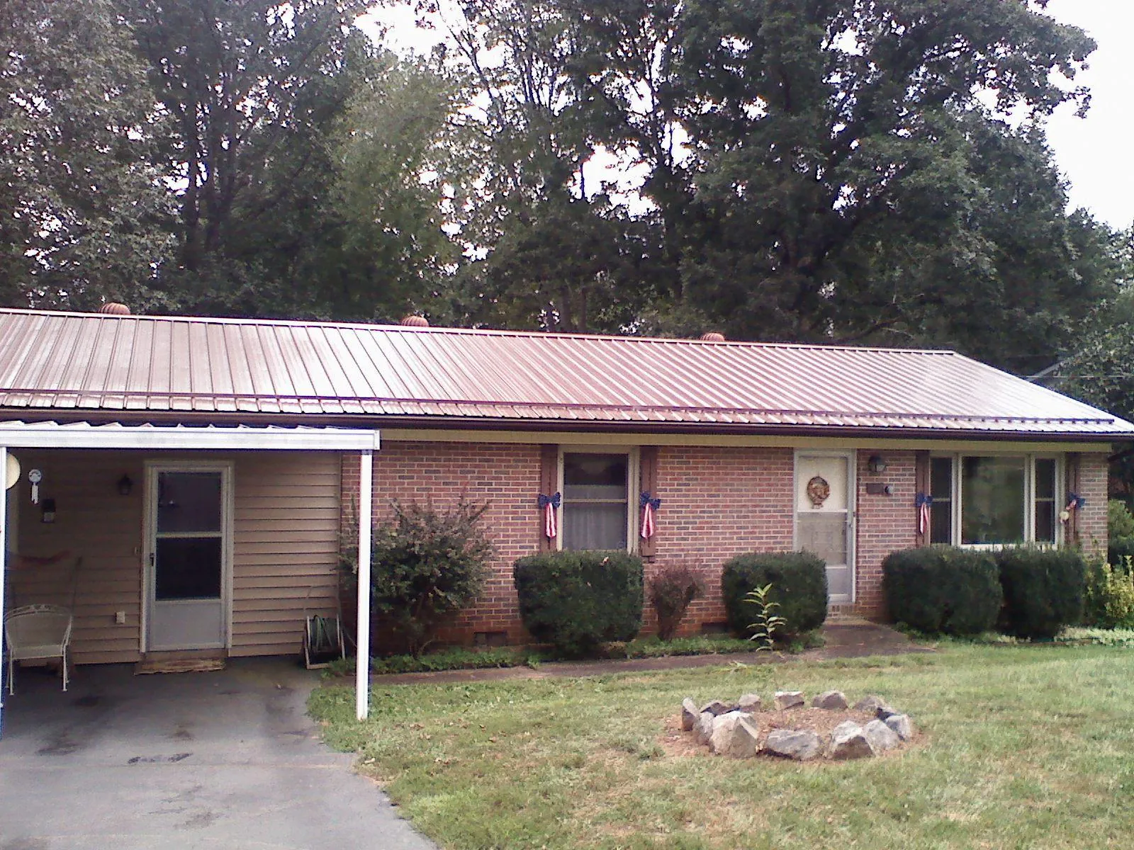Bronze metal roof and carport on a brick ranch home — Roof Repair work by our crew in Coalfield
